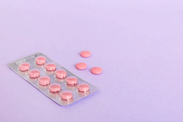 Blister package with Vitamin on color background. Medicine pills on a light background. Medicines and prescription pills flat lay background. pink medical tablets in blister.