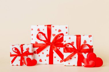 gift box with red bow and red heart on colored background. Perspective view. Flat lay.