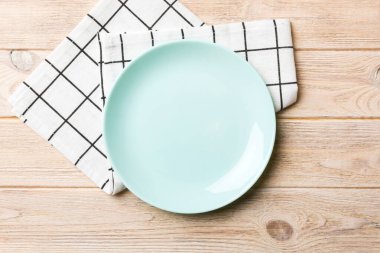 Renkli arkaplanda üst görünüm yiyecek için mavi tabak üzerinde boş. Tasarımınız için boşluk olan peçeteye boş tabak.