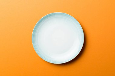 Renkli arka planın üst görüntüsü yiyecek için boş mavi tabak. Tasarımınız için alanı olan boş tabak.