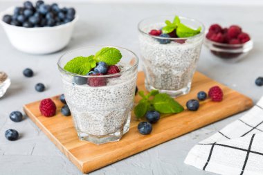 Sağlıklı kahvaltı ya da sabah chia tohumlu vanilyalı puding ahududu ve böğürtlen, vejetaryen gıda, diyet ve sağlık konsepti. Ahududu ve yabanmersinli Chia pudingi..