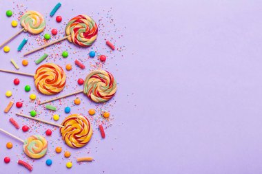 Lezzetli İştah açıcı Parti Aksesuarları Mutlu Yıllar Tatlı. Renkli arkaplanda farklı tipte şekerler, kopyalama alanı. Renkli doğum günü partisi geçmişi.