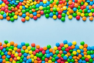 Renkli arka planda karışık renkli şeker koleksiyonu. Düz yerde, üst tarafta. Renkli çikolata kaplı şeker çerçevesi.