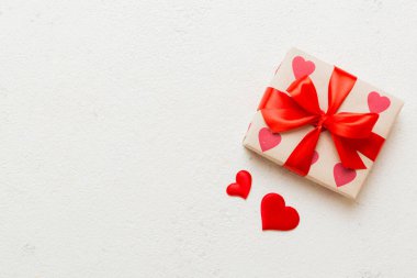 Top view photo of valentine day decorations gift box with red ribbon bow on colored background. Holiday gift boxes with top view. clipart