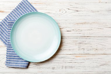 Renkli arkaplanda üst görünüm yiyecek için mavi tabak üzerinde boş. Tasarımınız için boşluk olan peçeteye boş tabak.