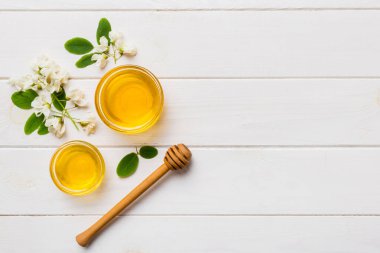 Akasya çiçekli ve yapraklı bal kavanozu. Taze bal üst görünüm düz yatıyordu.