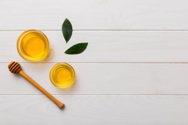 Bal kavanozu, beyaz arka plan manzaralı ve fotokopi alanı olan ahşap bal kaplama. Lezzetli bal şişesi.