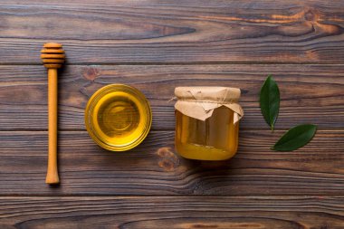 Bal kavanozu, beyaz arka plan manzaralı ve fotokopi alanı olan ahşap bal kaplama. Lezzetli bal şişesi.