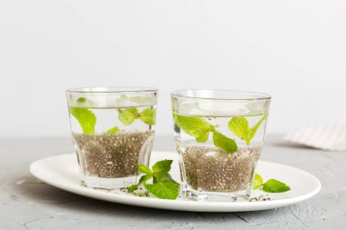 Sağlıklı kahvaltı ya da sabah chia tohumu ve nane arkaplanda, vejetaryen yiyecekler, diyet ve sağlık konsepti. Chia pudingi ve naneli.