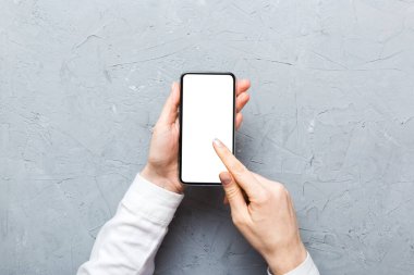 Mesajınız veya bilgi içeriğiniz için boş bir kopya ekranı olan akıllı telefonları tutan kadın ellerinin üst görünümü. üst görünümde telefon beyaz ekranı kullanan kadın eli.
