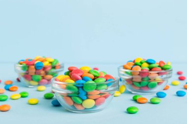 Renkli arka planda bir kasede çok renkli şekerler. Doğum günü ve tatil konsepti. Kopyalama alanı olan üst görünüm.