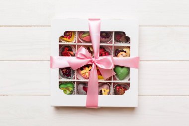 Valentine day composition: sweet candy, with gift boxes with bow and red felt hearts, photo template, background. Top View with copy space.