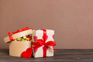Valentine day composition: sweet candy, with gift boxes with bow and red felt hearts, photo template, background. Perspective with copy space.