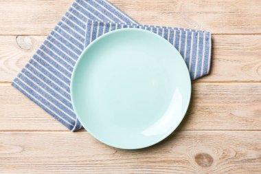 Renkli arkaplanda üst görünüm yiyecek için mavi tabak üzerinde boş. Tasarımınız için boşluk olan peçeteye boş tabak.