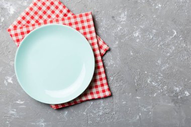 Renkli arkaplanda üst görünüm yiyecek için mavi tabak üzerinde boş. Tasarımınız için boşluk olan peçeteye boş tabak.