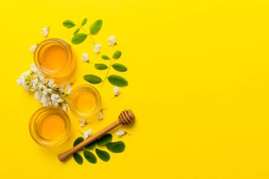 Akasya çiçekli ve yapraklı bal kavanozu. Taze bal üst görünüm düz yatıyordu.