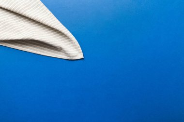 top view with gray kitchen napkin isolated on table background. Folded cloth for mockup with copy space, Flat lay. Minimal style.