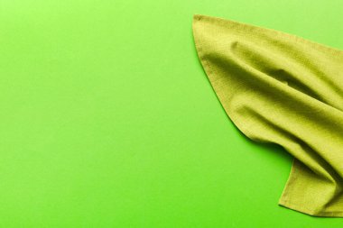 top view with green kitchen napkin isolated on table background. Folded cloth for mockup with copy space, Flat lay. Minimal style.