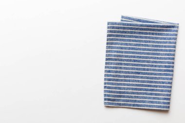 top view with blue kitchen napkin isolated on table background. Folded cloth for mockup with copy space, Flat lay. Minimal style.