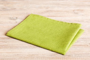 top view with green kitchen napkin isolated on table background. Folded cloth for mockup with copy space, Flat lay. Minimal style.