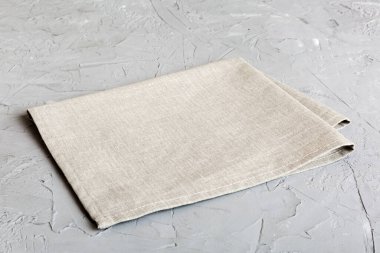 top view with gray kitchen napkin isolated on table background. Folded cloth for mockup with copy space, Flat lay. Minimal style.