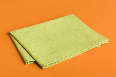 top view with green kitchen napkin isolated on table background. Folded cloth for mockup with copy space, Flat lay. Minimal style.