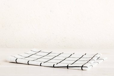 top view with white empty kitchen napkin isolated on table background. Folded cloth for mockup with copy space, Flat lay. Minimal style.