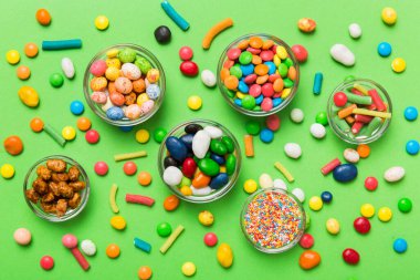 farklı renkte yuvarlak şekerler ve kavanozlar. Fotokopi alanı olan büyük çeşitlilikteki şeker ve şekerlerin üst görünümü.