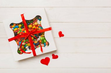 Valentine day composition: sweet candy, with gift boxes with bow and red felt hearts, photo template, background. Top View with copy space.