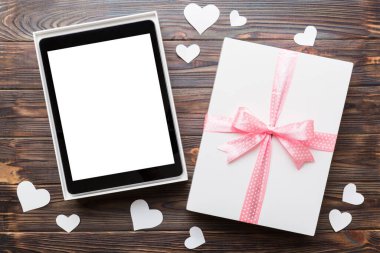 Gift box of open tablet for the holidays with a bow top view.