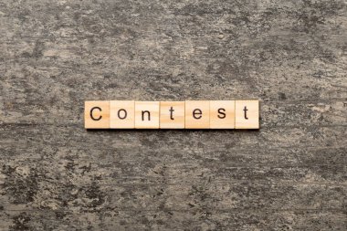 Tahta blokta yazan yarışma kelimesi. Üst görünüm konseptiniz için çimento tablosunda yarışma metni.