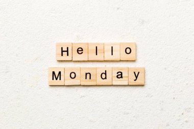 Merhaba pazartesi günü tahta bloğa yazılmış kelime. Merhaba pazartesi metni çimento masasında desing, konsept için.