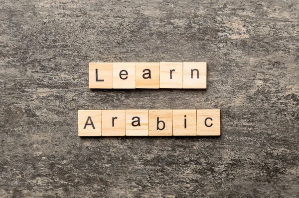 learn arabic word written on wood block. learn arabic text on table, concept.