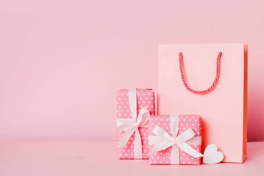 Shopping bag with gift box on colored background perspecrive view. Space for text holiday concept.