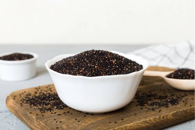 Kase içinde kinoa tohumu ve renkli arka planda kaşık. Küçük kasede sağlıklı kinwa. Sağlıklı süper yiyecekler.