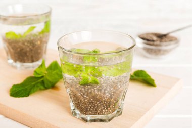 Sağlıklı kahvaltı ya da sabah chia tohumu ve nane arkaplanda, vejetaryen yiyecekler, diyet ve sağlık konsepti. Chia pudingi ve naneli.