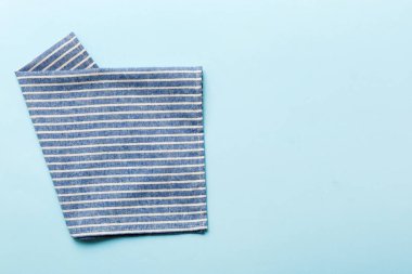 top view with blue kitchen napkin isolated on table background. Folded cloth for mockup with copy space, Flat lay. Minimal style.