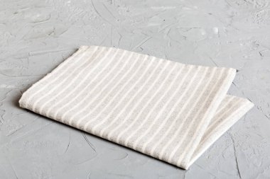 top view with gray kitchen napkin isolated on table background. Folded cloth for mockup with copy space, Flat lay. Minimal style.