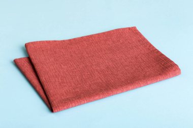 top view with red empty kitchen napkin isolated on table background. Folded cloth for mockup with copy space, Flat lay. Minimal style.