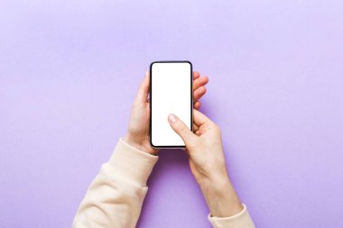 Mesajınız veya bilgi içeriğiniz için boş bir kopya ekranı olan akıllı telefonları tutan kadın ellerinin üst görünümü. üst görünümde telefon beyaz ekranı kullanan kadın eli.