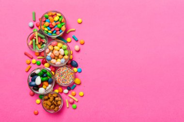 farklı renkte yuvarlak şekerler ve kavanozlar. Fotokopi alanı olan büyük çeşitlilikteki şeker ve şekerlerin üst görünümü.