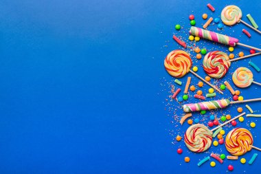 Lezzetli İştah açıcı Parti Aksesuarları Mutlu Yıllar Tatlı. Renkli arkaplanda farklı tipte şekerler, kopyalama alanı. Renkli doğum günü partisi geçmişi.