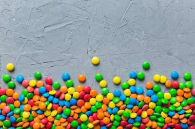 Renkli arka planda karışık renkli şeker koleksiyonu. Düz yerde, üst tarafta. Renkli çikolata kaplı şeker çerçevesi.