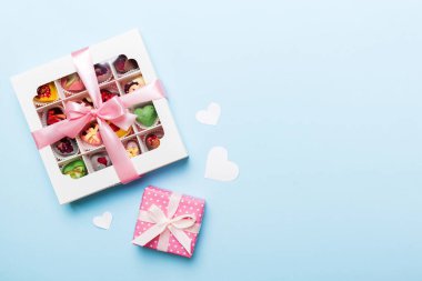 Valentine day composition: sweet candy, with gift boxes with bow and red felt hearts, photo template, background. Top View with copy space.