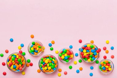 farklı renkte yuvarlak şekerler ve kavanozlar. Fotokopi alanı olan büyük çeşitlilikteki şeker ve şekerlerin üst görünümü.