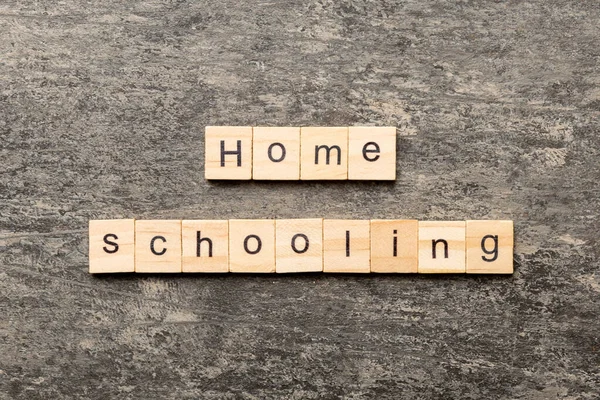 Home schooling word written on wood block. Home schooling text on table, concept.