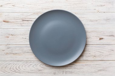 Ahşap zemindeki boş gri tabağın üst görüntüsü. Tasarımın için boş boşluk.
