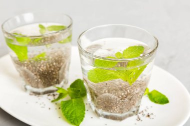 Sağlıklı kahvaltı ya da sabah chia tohumu ve nane arkaplanda, vejetaryen yiyecekler, diyet ve sağlık konsepti. Chia pudingi ve naneli.