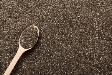 Space for text Texture of chia seeds with wooden spoon, superfood concept. Top view.