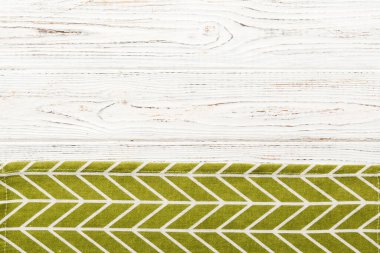 top view with green kitchen napkin isolated on table background. Folded cloth for mockup with copy space, Flat lay. Minimal style.